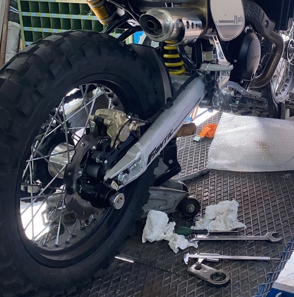 Manutenzione moto su cavalletto in officina.